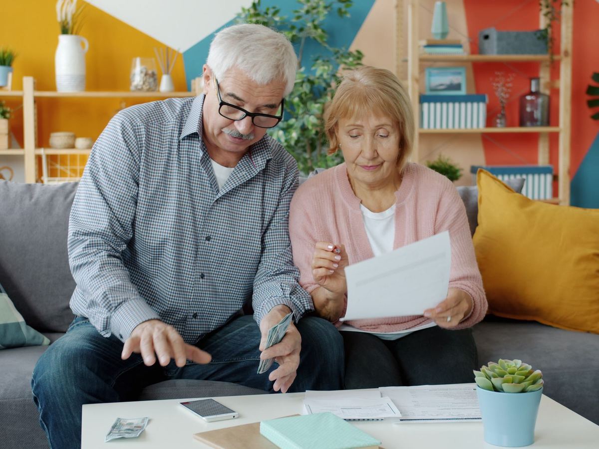 Retired couple going over their budget together on the sofa